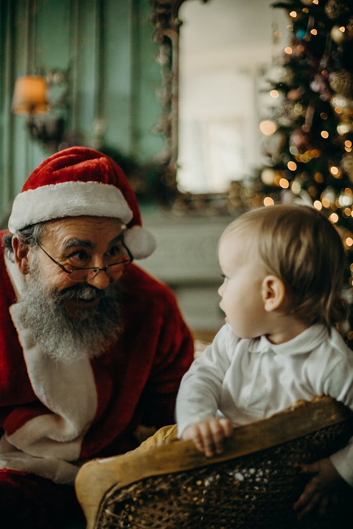 Adorable interaction between Santa Claus and a baby during a festive celebration.